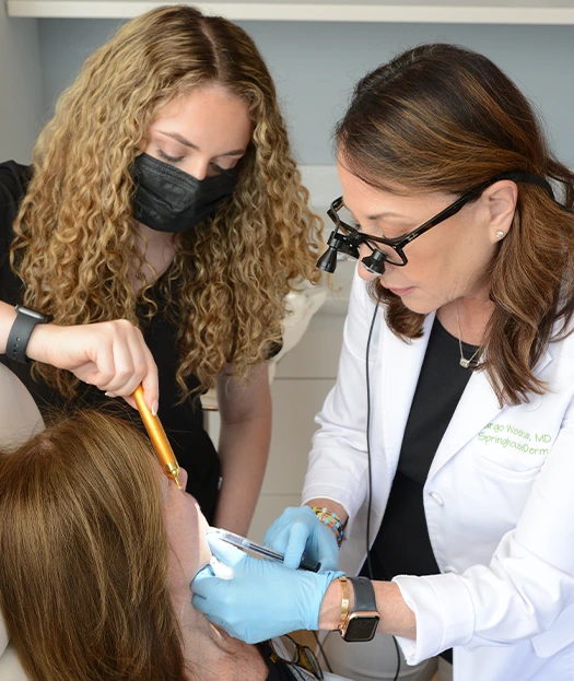 Dr. Weishar with an assistant during treatment of a patient