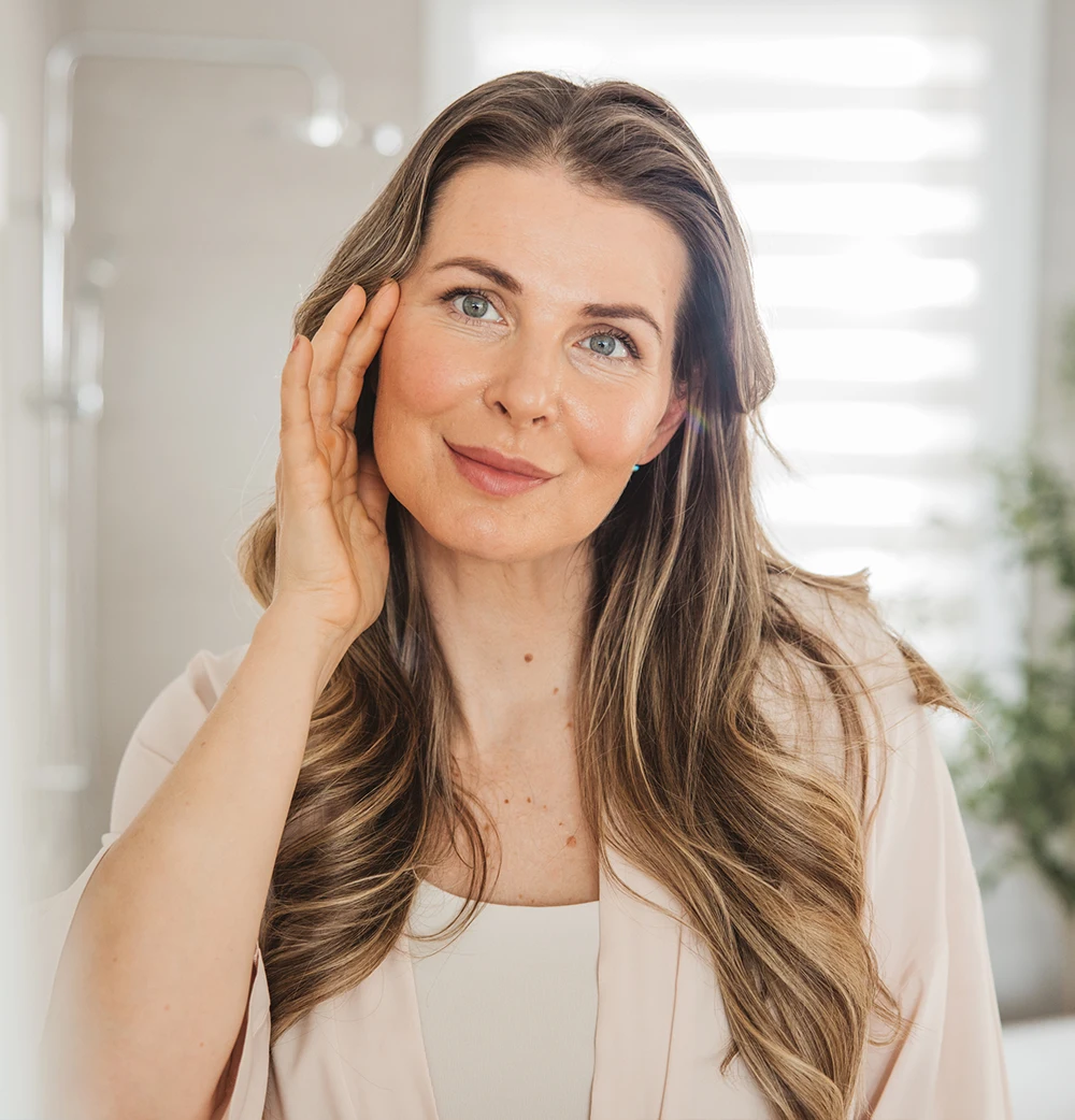 Cosmetic dermatology: A woman smiling with glowing skin, showing healthy facial features.