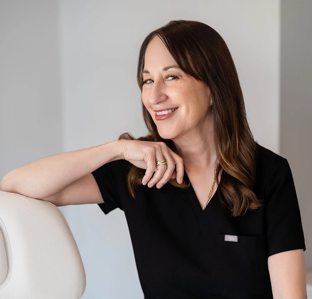 Board-certified dermatologist at Ambler Dermatology & Aesthetic Skin Care smiling in consultation room in Ambler, Pennsylvania.